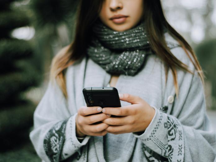 En ung person taster på sin telefon 